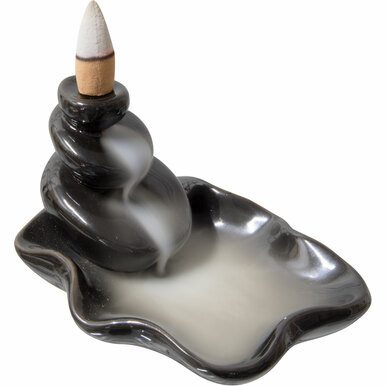 Ceramic backflow incense burner shaped like a water lily with smoke cascading down from a conical holder.