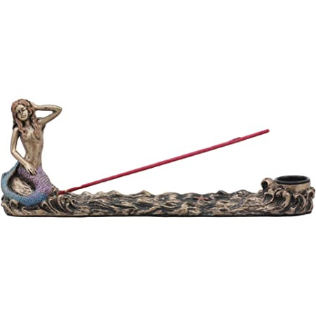 Bronze mermaid incense burner with colorful tail, resting on a wave-like base, holding an incense stick.
