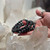 Hand holding Larvikite bracelet for size comparison, showcasing its captivating blue hues