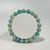 An amazonite gemstone bracelet, made of spherical, polished beads in shades of pale blue and green with some white marbling