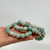Polished, spherical beads in shades of pale blue and green are strung together, forming three amazonite bracelets