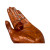 Natural amber necklace pendant displayed in a carved wooden hand, showcasing rich golden amber color and smooth polished finish.