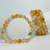 Citrine gemstone bracelet with polished yellow round beads displayed upright on a white background.