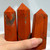 A hand holds three polished crystal points