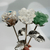 Close-up of Forever Rose stems with silver leaves and crystal-inspired rose blooms in white, green, and clear tones.