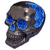 A black human skull figurine featuring a striking geode-style crystal effect. Brilliant, glittery royal blue crystals fill the eye sockets, the nasal cavity, and a large jagged vertical crack along the side of the cranium. The contrast between the smooth black finish of the bone and the textured, sparkling blue interior creates a vibrant, mystical aesthetic.