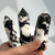A collection of polished Zebra Jasper crystal points featuring striking, high-contrast black and white natural patterns, carved into hexagonal towers with pointed tips