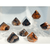 A collection of eight diamond-shaped sardonyx gemstones arranged on clear acrylic risers. The stones feature high-contrast concentric bands in shades of burnt orange, deep black, creamy white, and chocolate brown. Each stone has a sharp pointed top and a multi-faceted base.