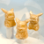 Three Yellow Calcite Pikachu carvings show a warm, sunny hue and smooth, polished surfaces that catch the light. They are displayed together on acrylic risers, highlighting the unique natural variations in each stone—from deep golden amber to lighter, creamy yellow tones.