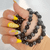 Genuine Tourmaline and Hematite gemstone bracelet with smooth polished beads wrapped around a hand.