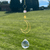Gold-toned amethyst and moon suncatcher with a sun charm and faceted crystal, hanging against a blurred grassy background.
