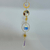 Gold-toned chakra tree-of-life suncatcher with multicolored stones, blue crystal sphere, sunburst ornaments, and a pointed hanging crystal.