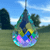 Faceted teardrop sun catcher hanging from a dark cord, reflecting turquoise, blue, purple, pink, green, and yellow light against a blurred outdoor background.