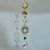 Hanging carnelian tree-of-life suncatcher with gold wirework, crystals, a sunburst frame, and a large faceted teardrop pendant.