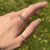 Multicolor Tourmaline eternity ring worn on a finger, showcasing colorful gemstones and a slim, elegant band in natural light.