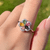 Multicolor Tourmaline Flower Ring worn on a finger, showcasing vibrant multi-tone tourmaline petals in natural light.