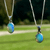 Handmade Ethiopian opal pendant necklace with an iridescent blue-green opal stone, shown outdoors in natural sunlight.