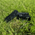 Rough black tourmaline crystals resting in green grass outdoors, highlighting their natural black color and rugged texture.