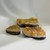 Three raw citrine specimens with a rough, crystalline surface sit on a white surface against a light gray background.