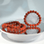 Polished, reddish-orange dyed howlite gemstone bracelets with black matrix