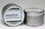 There are two silver, modern designed travel tins in the image. One tin is on it's side to show what the top of the label looks like on the lid: It says: sunshine underlined in the middle of the label, and is off set towards the left side in large text, cocoa butter-jasmine is written below in a smaller font. The Blue Flame logo is at the top of the label. Soy-blend Candle is written on the right side in a vertical line. On the bottom of the label is written, Exceptionally Fragrant. The other tin is flat and shows that the tin is just silver without a wrap around label. The modern design uses pale hues and simplistic lines.