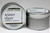 There are two silver, modern designed travel tins in the image. One tin is on it's side to show what the top of the label looks like on the lid: It says, winter cheer underlined in the middle of the label, and is off set towards the left side in large text, cranberry-cinnamon are written below in a smaller font. The Blue Flame logo is at the top of the label. Soy-blend Candle is written on the right side in a vertical line. On the bottom of the label is written, Exceptionally Fragrant. The other tin is flat and shows that the tin is just silver without a wrap around label. The modern design uses pale hues and simplistic lines.