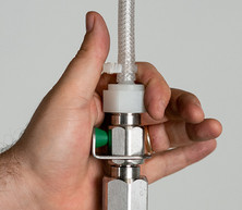 Hand holding Crystal Spring H19-0052 quick connect valve on a waterline