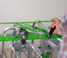 Hand operating the green upper-frame handle on a Crystal Spring Freedom Stall