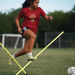 soccer player hurdling over Agility poles
