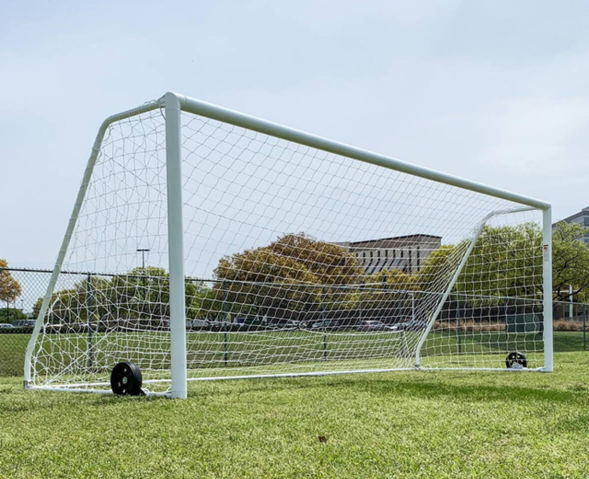 Full-sized white soccer goal on a field.