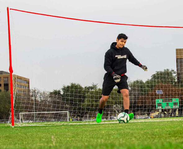 Adult footballer performs ladder speed drill wearing men’s soccer gear