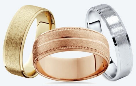 three plain wedding bands in gold, rose gold, and white gold