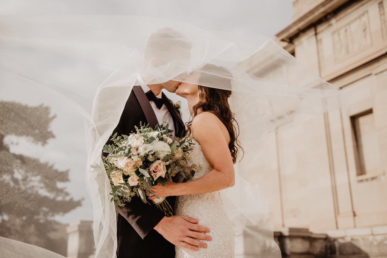 couple kissing with veil over them