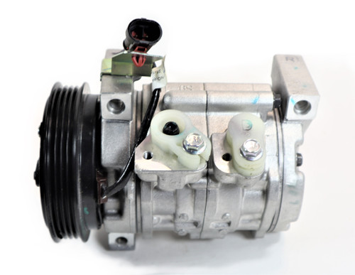 Mahindra A/C compressor 008012969U91 shown as a belt‑driven automotive‑style compressor mounted on the engine of 6065/6075, 7095, 8090 and 8100 cab tractors, circulating refrigerant through the HVAC system to provide cold air in the operator cab.