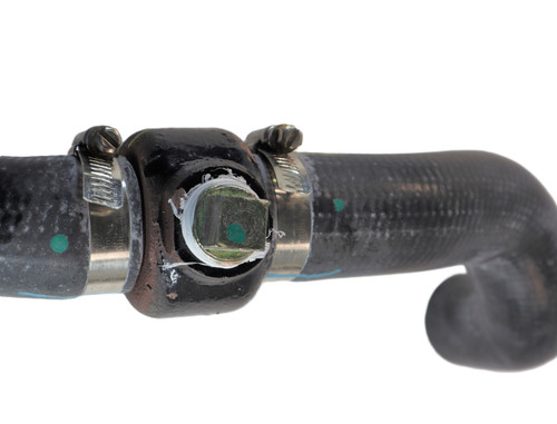 Mahindra block heater housing assembly with hoses 006006174D91 / 006006174D92 / E006006174D91 for Mahindra 35, 3500 and 3600 Series tractors, used in the engine cooling system to circulate warmed coolant for easier cold‑weather starting; heating element not included.