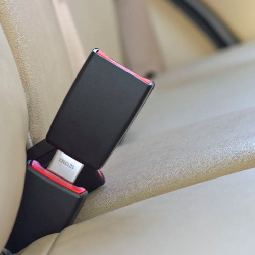 Black, rigid Skoda Favorit three-inch seat belt extender buckled into the back seat