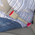 Rigid beige seat belt extender in use with a plus sized man in a striped shirt and jeans.