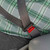 Regular gray seat belt extender in use with a plus sized man in a patterned shirt.
