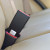 Black, rigid Vauxhall Adam three-inch seat belt extender buckled into the back seat