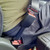 Black, rigid Volvo Truck Seat Belt Extender buckled around a plus-sized passenger up close