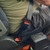 Black, rigid GMC Savana Cutaway Van Seat Belt Extender buckled around a plus-sized passenger Wider View