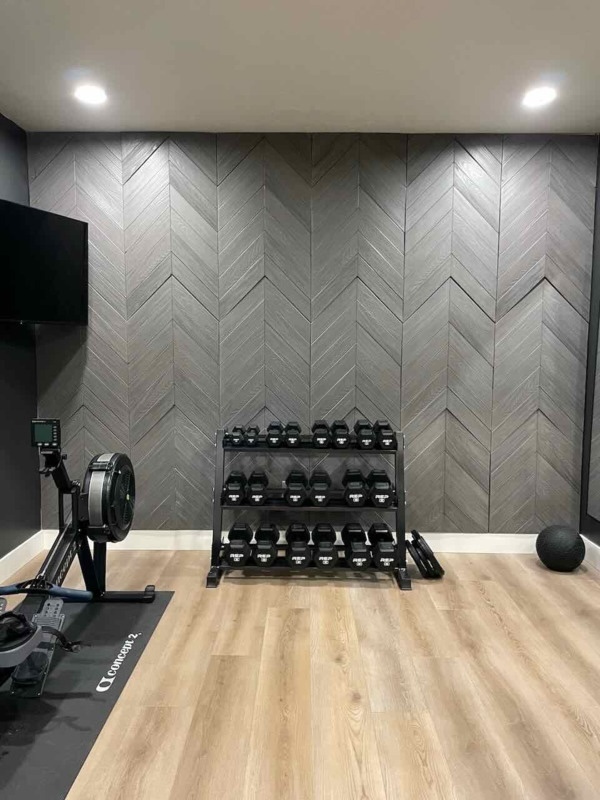 Chevron Faux Wood Panels in Graphite Lead installed on a modern style home gym wall.