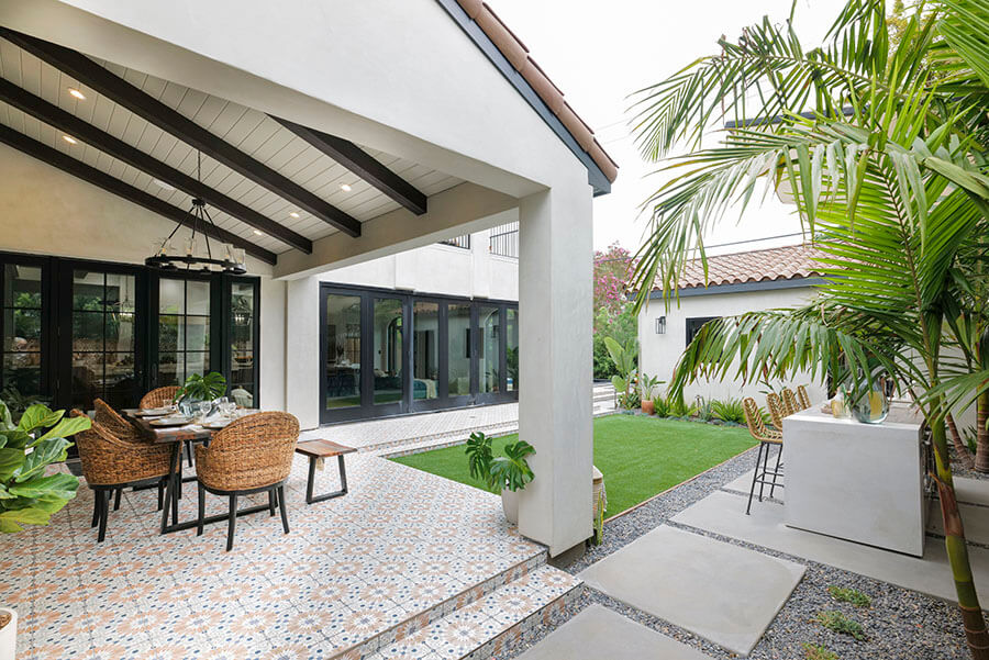 Faux wood beams across the ceiling of a back porch help to create a natural, Southwestern-style entertaining area.