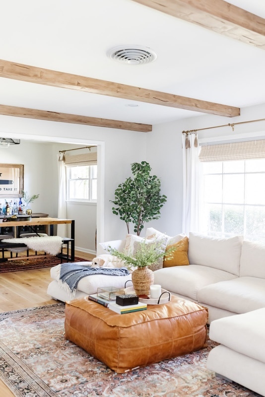 Hand Hewn Faux Wood Beams in Light Oak installed on a ceiling for a bright and airy boho style living room.