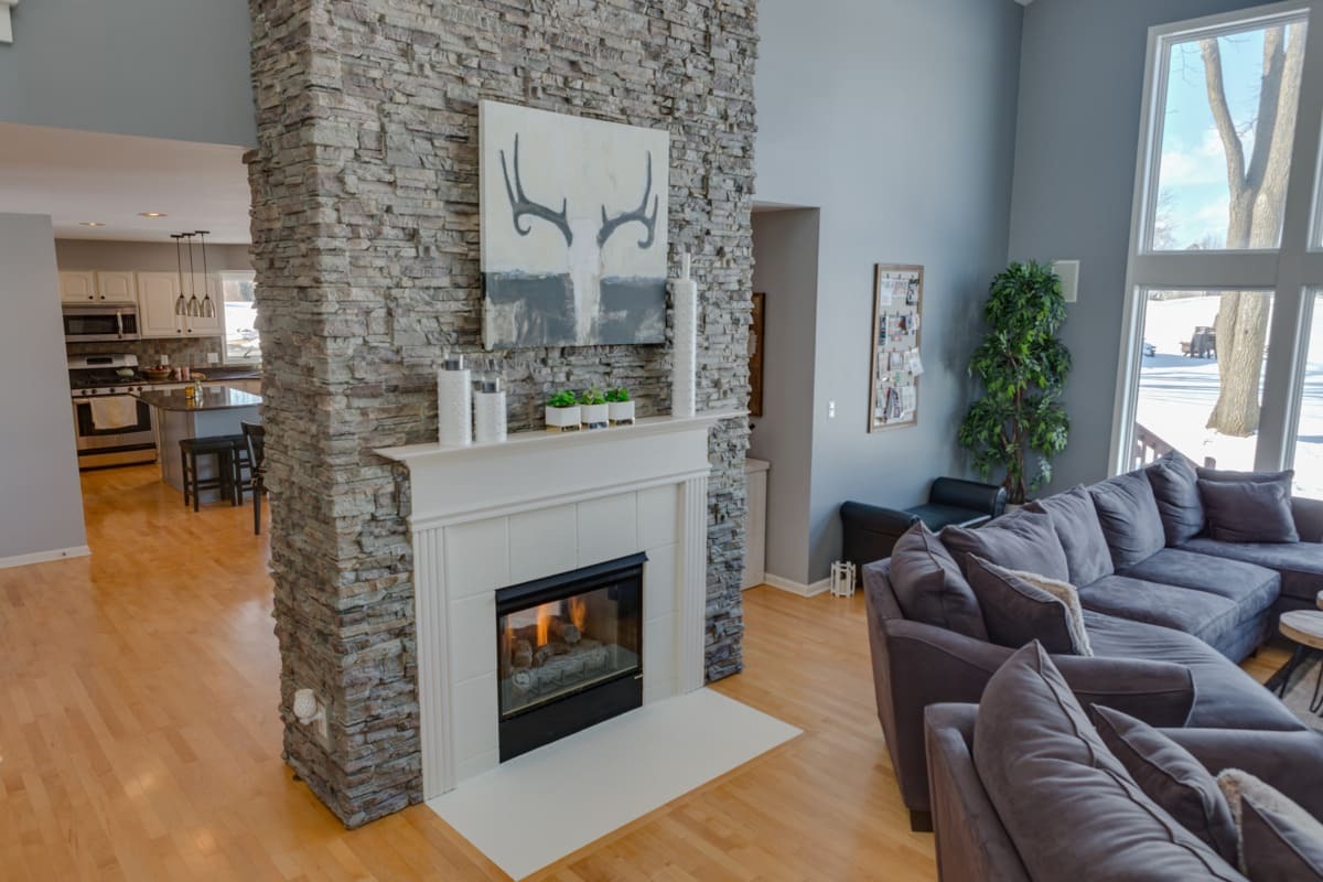 Colorado Dry Stack Faux Stone Wall Panels in Mist encasing a chimney in a traditional style living room.