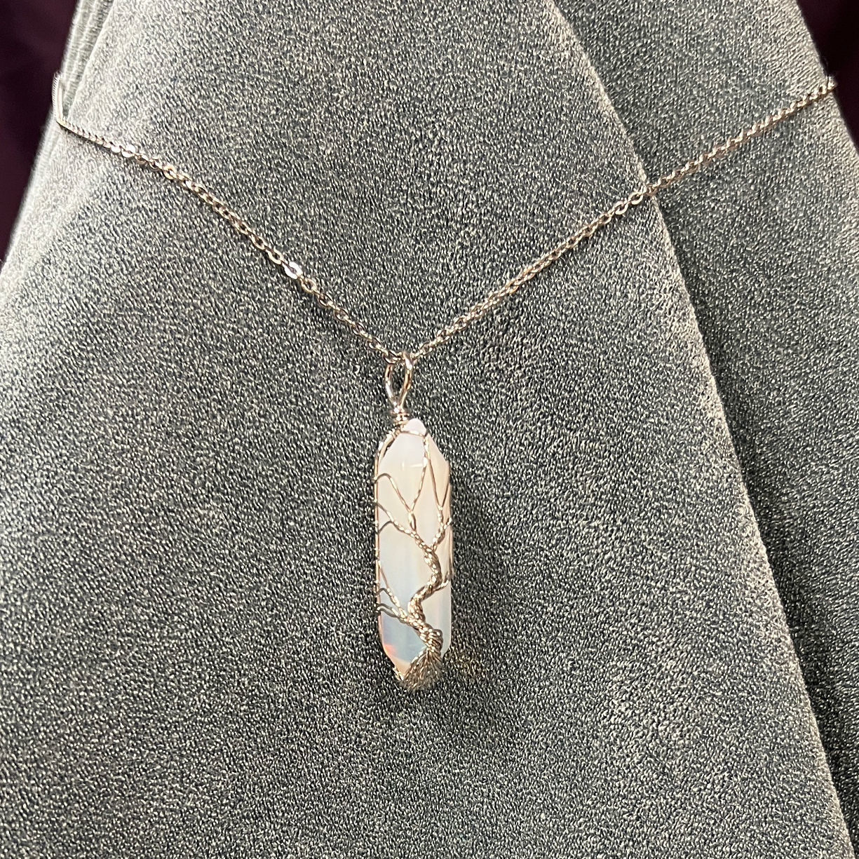 Opal gemstone wrapped with wire in a tree Tree of Life design, hangs from 19" silver chain with 1/4" bale