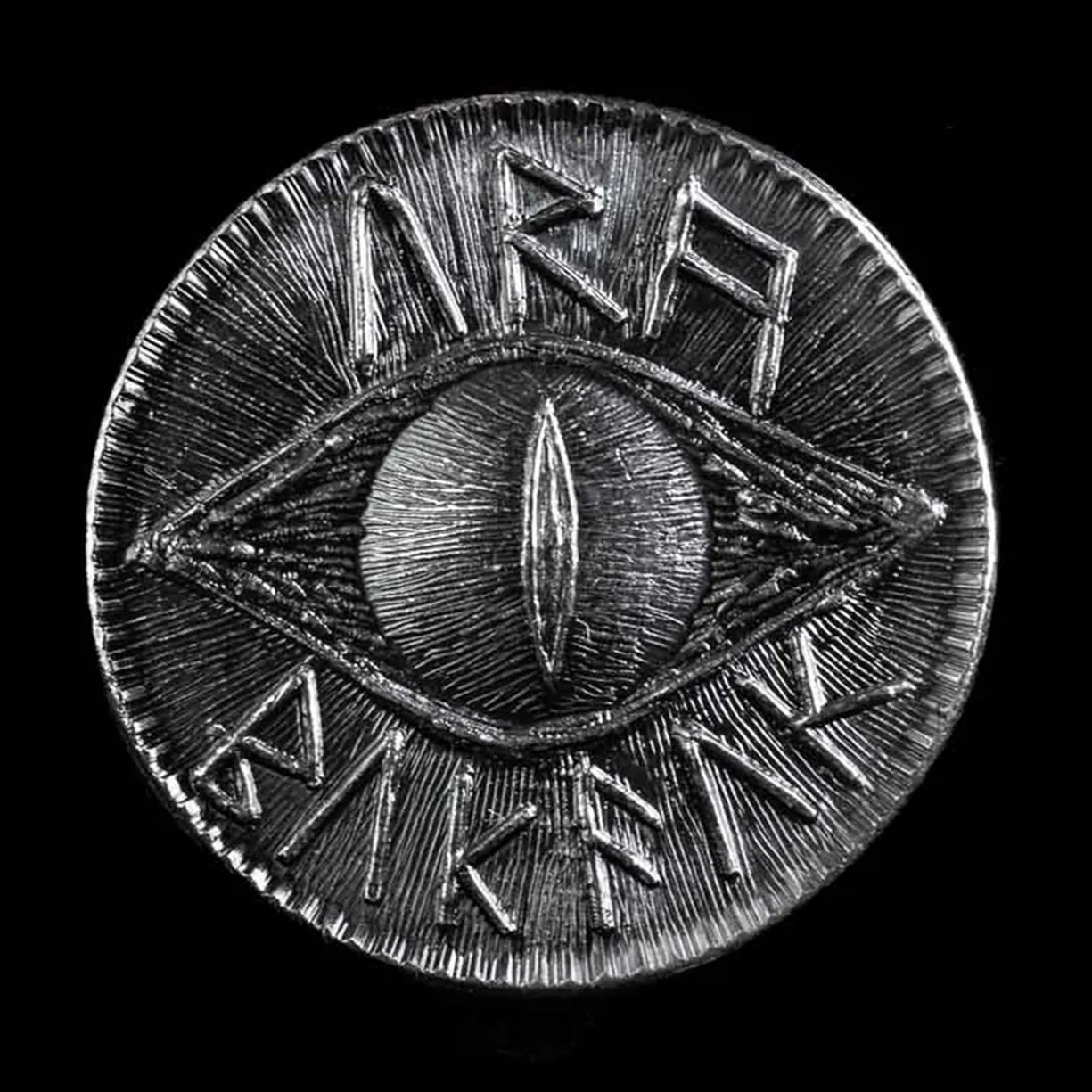 Solid black iron Eye of Sauron LOTR coin has a crude eye surrounded by runes meaning "OBEY MORDOR"