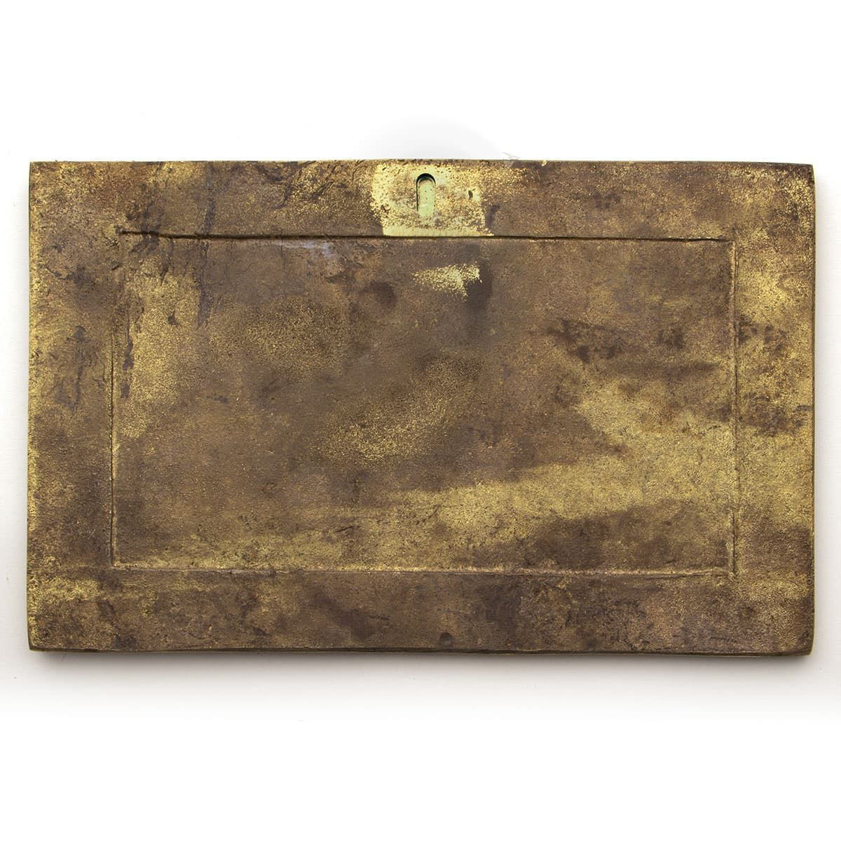 back of solid brass plaque of winged dragon