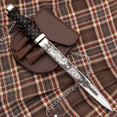 Scottish dirk has sharp 1080 high carbon steel blade etched on both sides with foliage and thistle motif, includes leather sheath