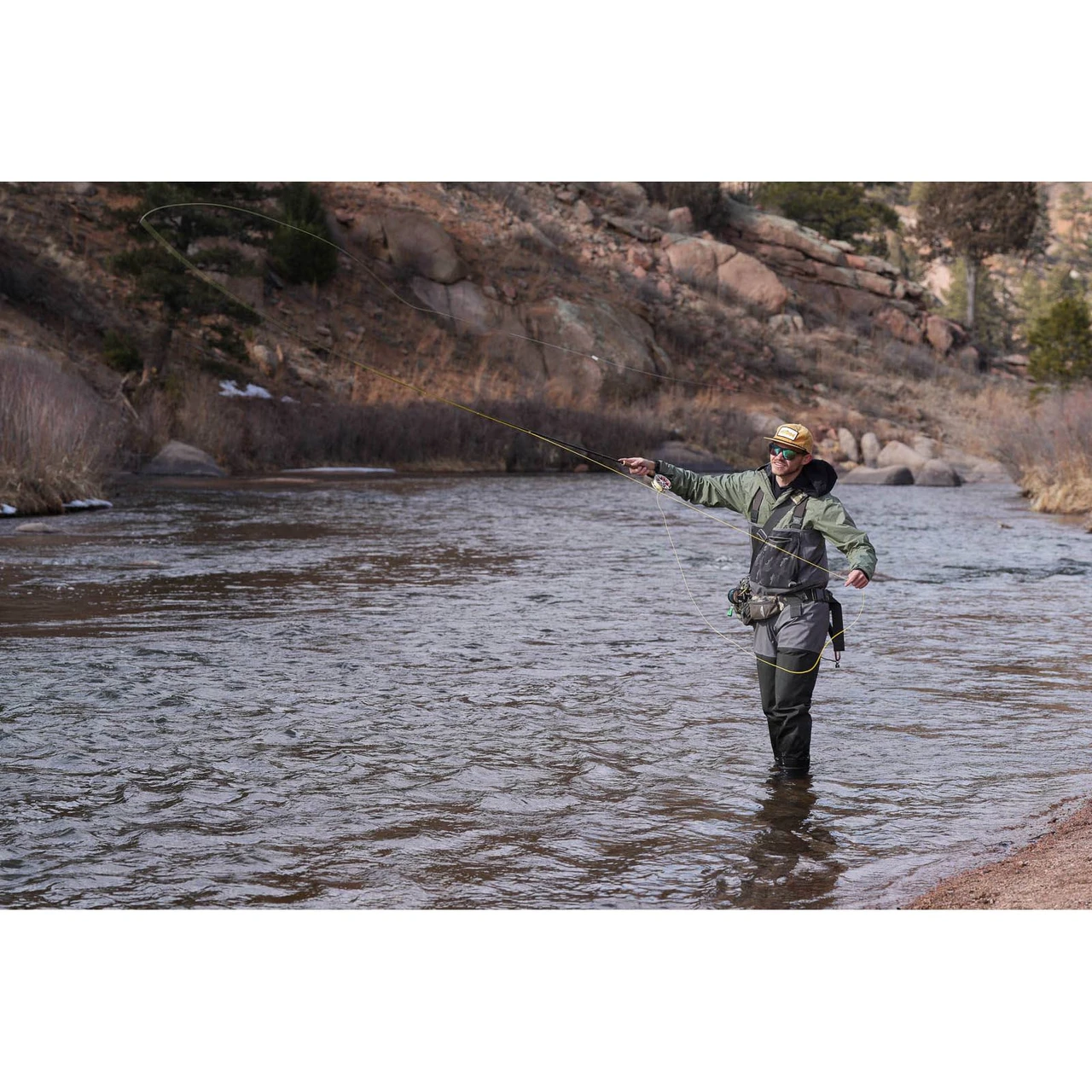 Angler casting a Scott Session fly rod on a trout river
